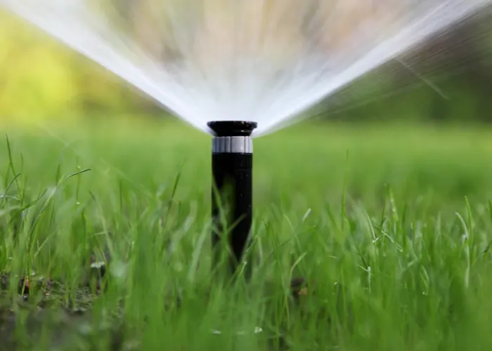 A sprinkler watering a lawn and providing sustainable water use